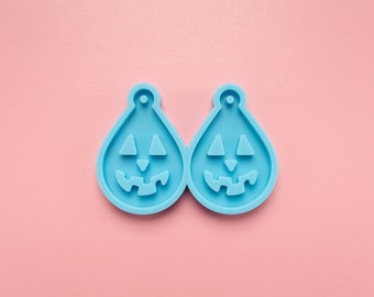 May include: A pair of light blue silicone molds shaped like jack-o'-lanterns. The molds are designed for making earrings or other small crafts.