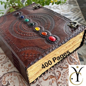 May include: A brown leather-bound journal with a decorative embossed design and colorful gemstones. The journal has 400 pages and is perfect for writing, journaling, or sketching.