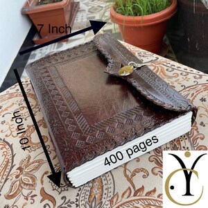 May include: A brown leather journal with embossed geometric patterns and a clasp closure. The journal measures 10 inches by 7 inches and contains 400 pages. The cover has a decorative border and a secure lock.