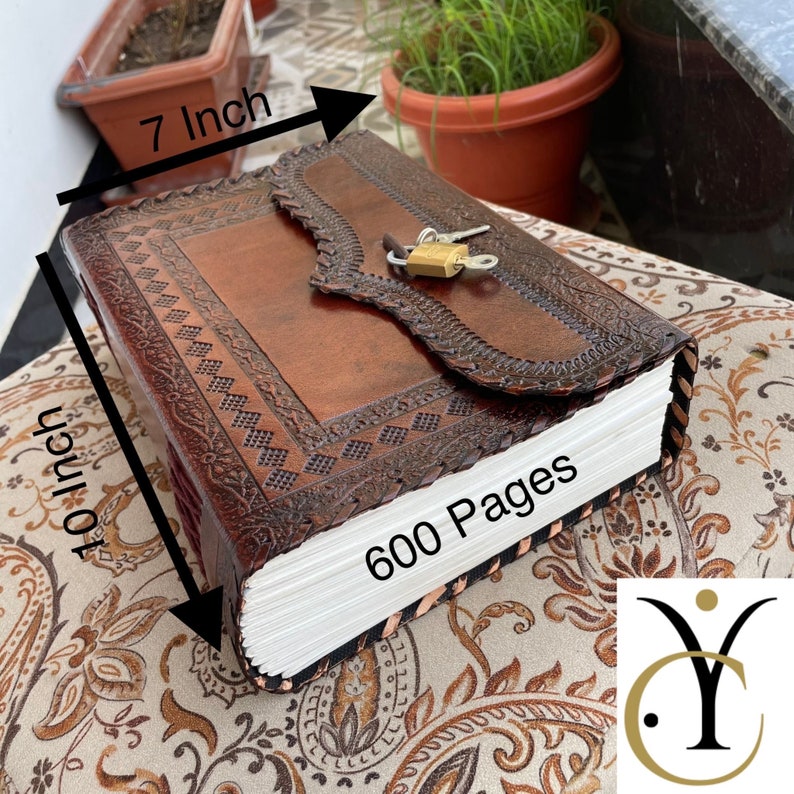 May include: A brown leather journal with a decorative embossed design and a lock closure. The journal measures 10 inches by 7 inches and contains 600 pages. The journal is a rich brown color.