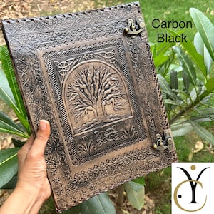 May include: A rectangular carbon black leather journal featuring an embossed tree of life design on the front cover, surrounded by intricate floral and geometric borders. The journal is secured with two antique brass-coloured metal swing latches.