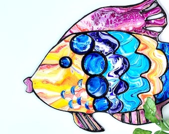 May include: A colorful, abstract fish wall art piece with a pink, yellow, blue, and purple paint design. The fish is outlined in black and has a white background.