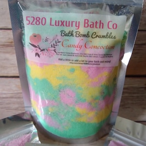 Puede incluir: Una bolsa de plástico transparente llena de migajas de bomba de baño de colores. La bolsa tiene una etiqueta que dice "5280 Luxury Bath Co Bath Bomb Crumbles Candy Concoction". La etiqueta también incluye un pequeño diseño floral y el texto "¡Añade un poco o mucho a tu baño y disfruta! etsy.com/shop/5280luxurybathco"