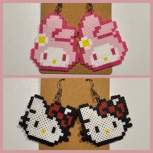 May include: Two pairs of Hello Kitty earrings made with perler beads. The first pair features Hello Kitty with a pink bow and a yellow flower. The second pair features Hello Kitty with a black bow and a red flower.