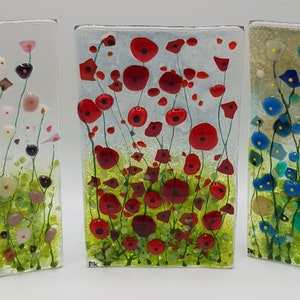 May include: Three glass panels with a stained glass design of colorful flowers. The panels feature red, pink, blue, and green flowers on a white background.