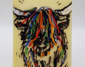 Può includere: Un'opera d'arte in vetro colorato che rappresenta una mucca delle Highlands con un contorno nero e uno sfondo giallo. Il pelo della mucca è fatto di pezzi di vetro colorati, tra cui rosso, arancione, giallo, verde, blu e viola. L'opera è firmata "DK."