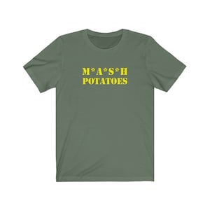 Puede incluir: Una camiseta verde con el texto "M*A*S*H POTATOES" en amarillo.