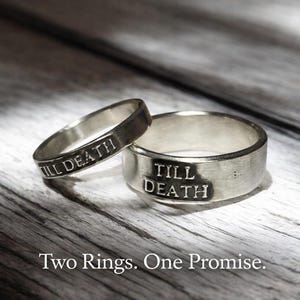 May include: Two silver rings with the words "TILL DEATH" engraved on them. The rings are displayed on a wooden surface. The image also includes the text "Two Rings. One Promise."