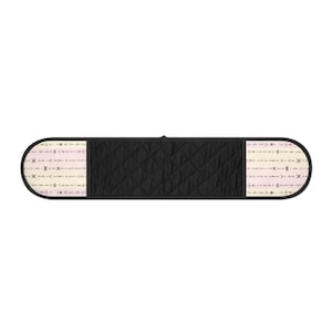 May include: Black quilted double oven mitt with a geometric pattern on the ends. The ends have a cream background with a repeating pattern of arrows and other shapes in shades of pink and brown.