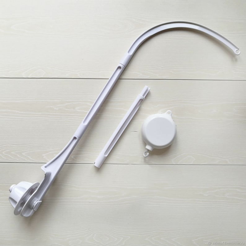 May include: White plastic baby cot mobile arm with a round base and a curved arm. The arm is in three pieces, with a separate rotating base and a connecting rod.