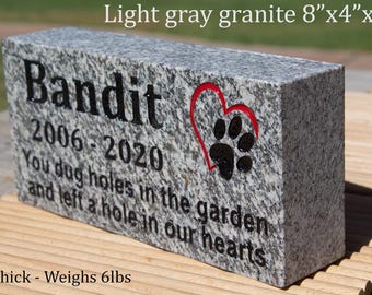 May include: Light gray granite pet memorial stone, 8" x 4" x 2", with the name "Bandit" and dates 2006-2020. Includes a paw print inside a red heart. The inscription reads "You dug holes in the garden and left a hole in our hearts."