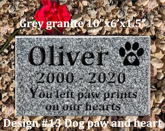 May include: Grey granite pet memorial stone with the name Oliver, dates 2000-2020, and the inscription "You left paw prints on our hearts". The stone features a black paw print with a heart inside. Design #13 Dog paw and heart.
