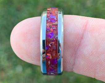 May include: A silver ring with a band of red and purple opal inlay.