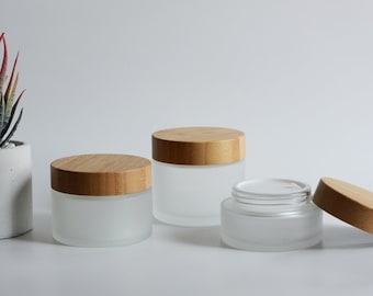 May include: Three frosted glass jars with bamboo lids. The jars are empty and have a frosted finish. The lids are made of natural bamboo.