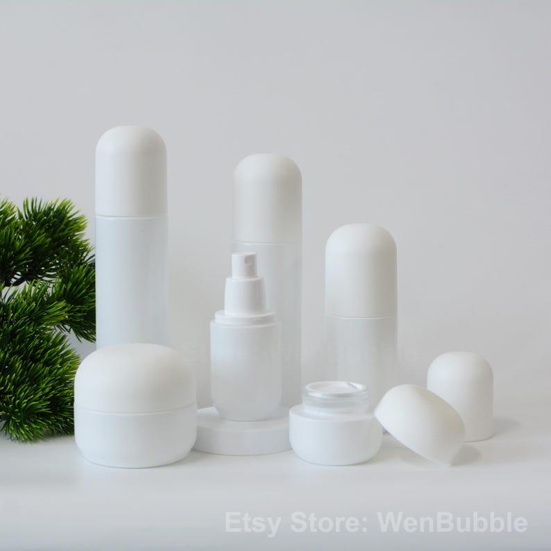 Peut inclure: Ensemble de six flacons en verre givr&eacute; blanc de diff&eacute;rentes tailles et formes. Les flacons ont des bouchons blancs et sont dispos&eacute;s sur une surface blanche. Les flacons sont parfaits pour stocker et distribuer des lotions, des cr&egrave;mes et d'autres liquides.