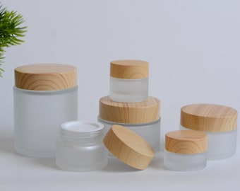 May include: A collection of frosted glass jars with wooden lids. The jars vary in size and shape, some with contents visible. The lids are light brown, and the jars are arranged on a white surface. The text "WenBubble" is visible in the bottom right corner.