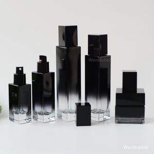 May include: A collection of black glass perfume bottles with square, black lids. The bottles are different sizes and shapes, with a gradient effect from black to clear. The text "WenBubble" is visible on the bottles.