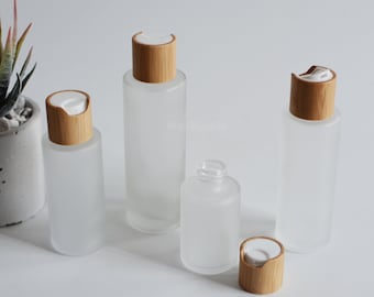 May include: Set of four frosted glass bottles with bamboo lids. The bottles are various sizes and are perfect for storing essential oils, lotions, or other liquids.