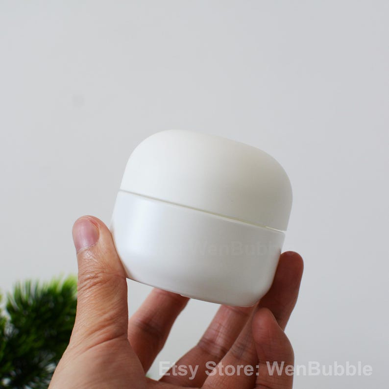 Peut inclure: Pot en plastique blanc avec un couvercle arrondi. Le pot est vide et a une surface lisse.