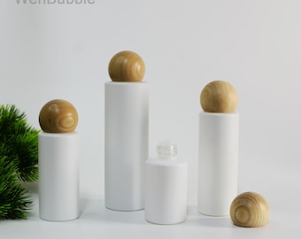 May include: White cylindrical bottles with wooden spherical stoppers. One bottle is shorter with a clear glass top. The text "WenBubble" is in the top left and bottom right corners.