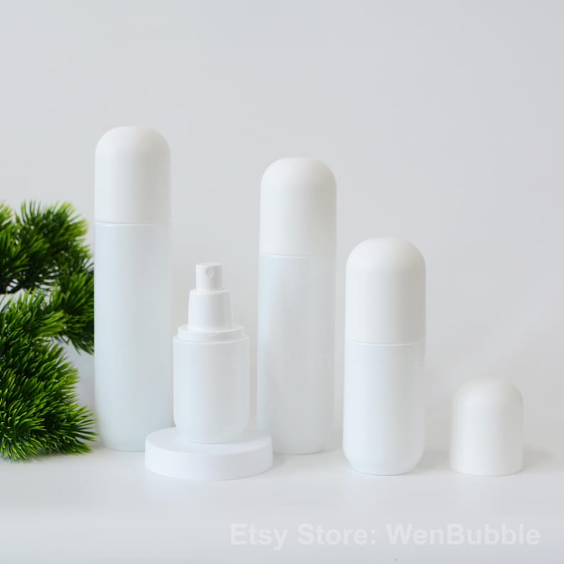 Peut inclure: Quatre flacons en plastique blanc avec des bouchons ronds. Les flacons sont de tailles diff&eacute;rentes et sont dispos&eacute;s en rang&eacute;e sur une surface blanche. Les flacons sont vides et ne portent aucune &eacute;tiquette.