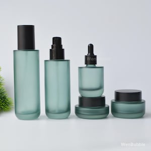Mat donkergroene glazen huidverzorgingsset, lege pipet, crèmepotjes, lotionflesjes, navulbare cosmetische verpakkingen, doe-het-zelf beautyproducten