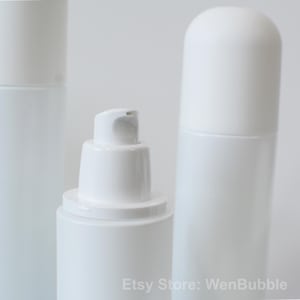 Peut inclure: Trois flacons en plastique blanc avec diff&eacute;rents types de pompes. Le flacon de gauche a une pompe simple, le flacon du milieu a une pompe avec un long bec verseur et le flacon de droite a un bouchon en forme de d&ocirc;me.