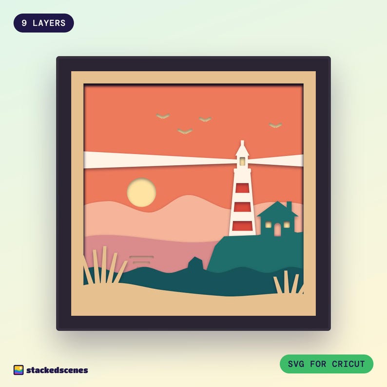 Finished 9-layer paper shadow box of a red and white striped lighthouse and cottage on teal cliffs, with light beams across a coral sunset sky.