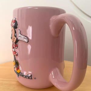 May include: A set of three ceramic mugs with a speckled, matte finish. The mugs are in shades of cream, light grey, and dark grey. Each mug has a simple, modern design and a rounded handle. Ideal for tea or coffee.