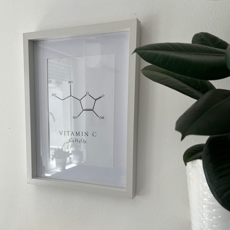 Pu&ograve; includere: Una stampa incorniciata con un'illustrazione in bianco e nero della struttura chimica della vitamina C, con il testo "VITAMIN C C6H8O6" sotto l'illustrazione.