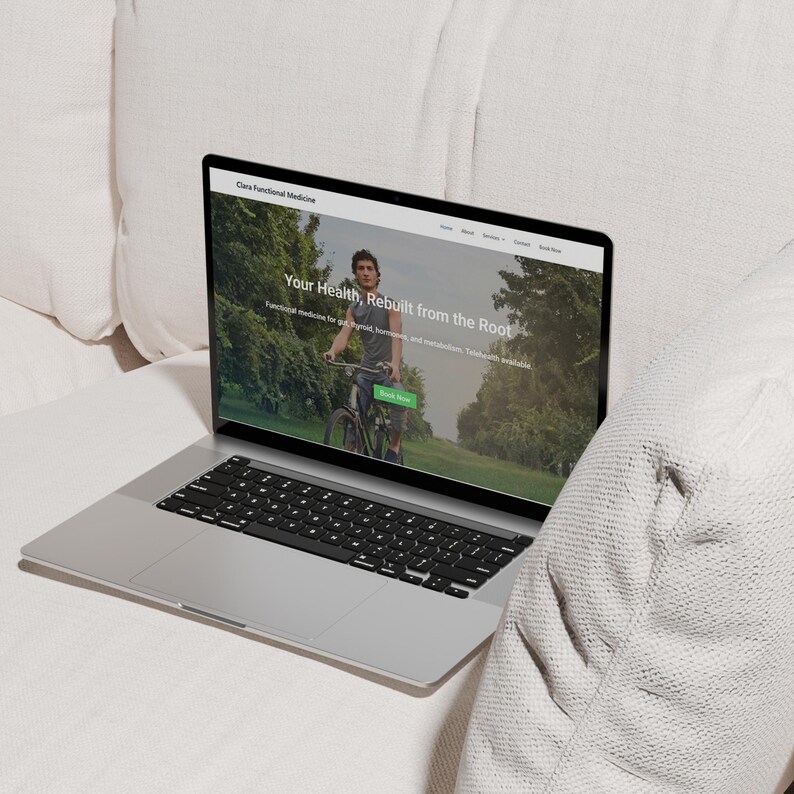 K&ouml;nnte beinhalten: Ein silberner Laptop, der eine Website mit dem Text "Your Health, Rebuilt from the Root" anzeigt. Der Bildschirm zeigt eine Person, die in einem Park Fahrrad f&auml;hrt. Der Laptop ist auf einer wei&szlig;en Oberfl&auml;che ge&ouml;ffnet, mit einer schwarzen Tastatur und einem schwarzen Bildschirmrand.