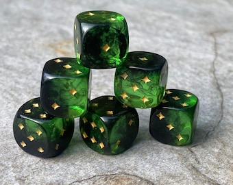 Pode incluir: Seis dados verdes com estrelas douradas em cada face, empilhados em forma de pirâmide.