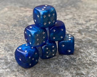 May include: A stack of six blue dice with silver star-shaped pips. The dice are arranged in a pyramid shape.