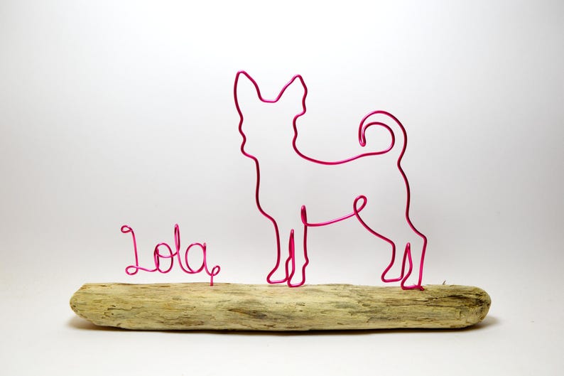 May include: Pink wire sculpture of a chihuahua dog with the name "Lola" written in pink wire on a driftwood base.