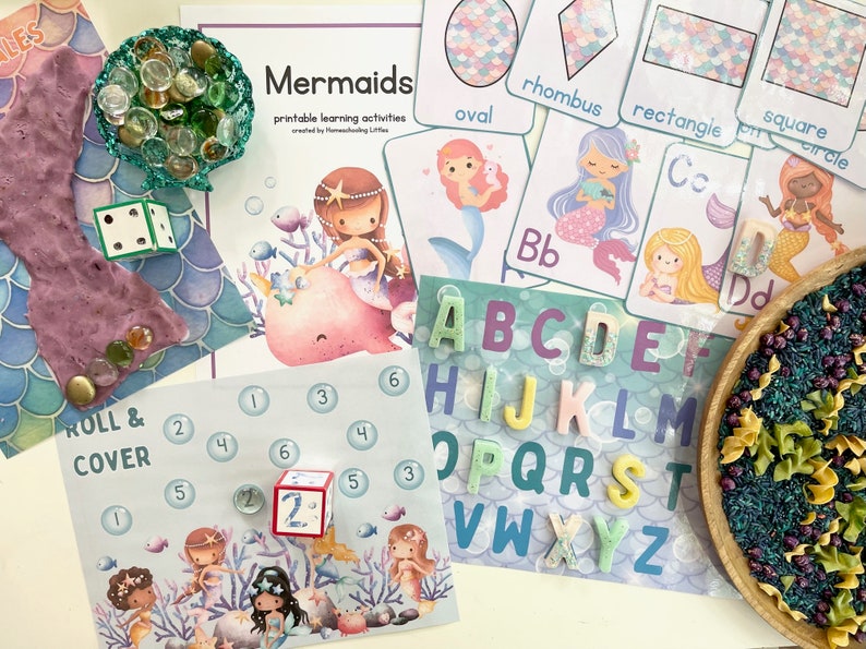 May include: A mermaid-themed learning activity set with colorful alphabet tiles, a dice game, and a printable activity sheet with the text "Mermaids printable learning activities created by Homeschooling Little."