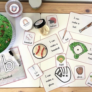 May include: A set of printable cards for a baseball-themed sensory bin activity. The cards feature images and text related to baseball, such as a bat, ball, glove, and field. The text on the cards reads "I can make a..." followed by the name of the item. The cards are printed on white cardstock with red borders.