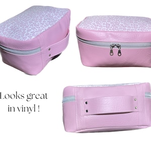 May include: Three pink vinyl cosmetic bags with a white leopard print design. The bags have a zipper closure and a handle. One bag is open to show the interior.