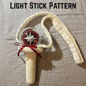May include: White crocheted light stick holder with a red ribbon and a clear plastic sphere containing a red and silver star. The holder has a strap for carrying.