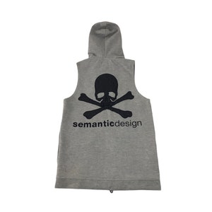 May include: A sleeveless gray hoodie with a black skull and crossbones design on the back. The text "semanticdesign" is printed below the graphic. The hoodie has a hood and a full-length zipper.