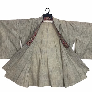 May include: A traditional Japanese kimono with a gray and white striped pattern. The kimono is open to reveal a colorful floral lining.