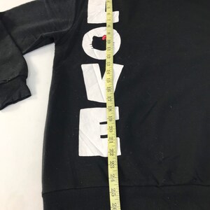 May include: Black hooded sweatshirt with the word "LOVE" printed vertically in large white letters. The "O" features a cartoon cat face. The sweatshirt has a drawstring hood and ribbed cuffs and hem. The length of the sweatshirt is approximately 28 inches.
