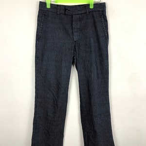 May include: Navy and white striped trousers hanging on a green hanger. The trousers feature a straight leg cut and a button and zip fastening. The fabric has a vertical stripe pattern.