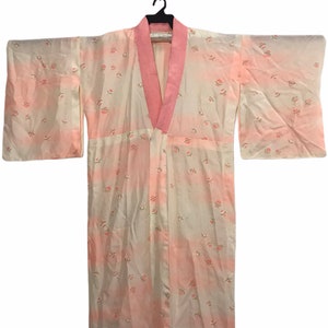 May include: A pink and white Japanese kimono with a floral pattern. The kimono has a pink collar and a white background with a subtle ombre effect.
