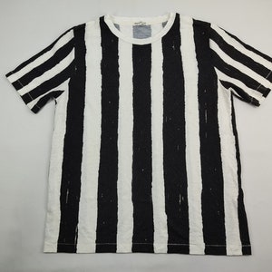 May include: Black and white striped short-sleeved t-shirt with a crew neck.