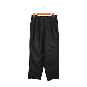 Könnte beinhalten: Dunkelgraue Hose mit Falten, die an einem Holzbügel hängt. Die Hose hat einen Knopfverschluss und Taschen. Der Stoff scheint ein gewebtes Material zu sein. Die Hose wird vor einem weißen Hintergrund präsentiert.