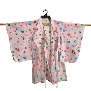 May include: White cotton yukata with a colorful beach ball pattern. The yukata has a traditional Japanese style with wide sleeves and a sash.