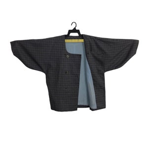 May include: A black and gray checkered jacket with a blue lining. The jacket has a button closure and two pockets.