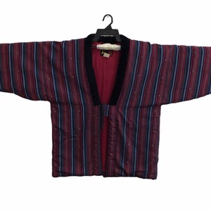 May include: A striped burgundy and blue kimono with a black velvet collar. The kimono is open at the front and has a long, flowing silhouette.
