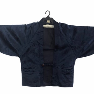 May include: A dark blue velvet kimono with a tie closure and a textured pattern.