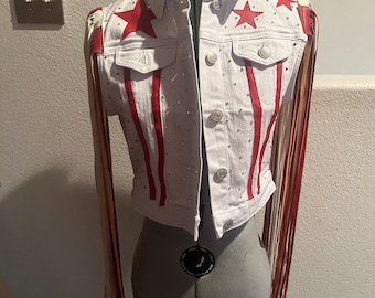 May include: White denim jacket with red and white stripes, red stars, and fringe detailing.